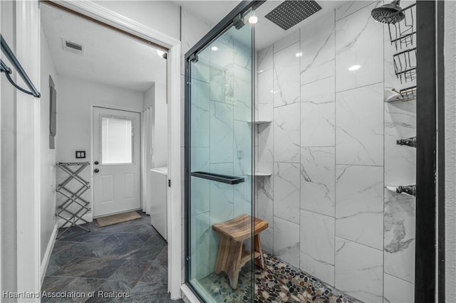 bathroom with a shower with door and washer / dryer