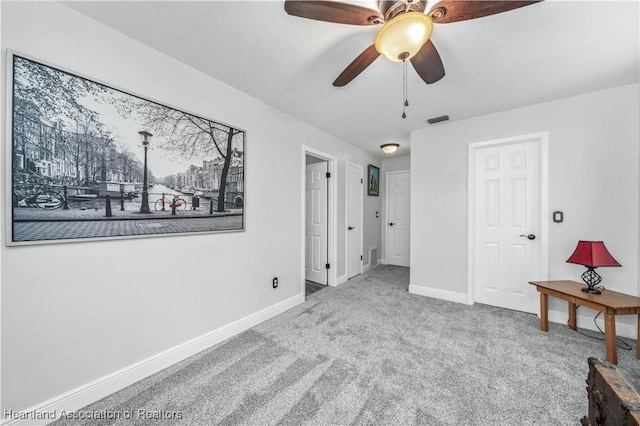 interior space with carpet flooring and ceiling fan