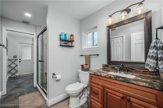 bathroom with vanity, toilet, and a shower with shower door