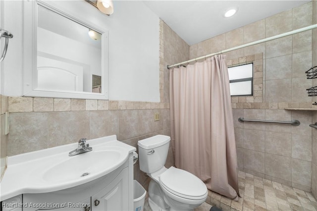 bathroom with a shower with curtain, vanity, tile walls, and toilet