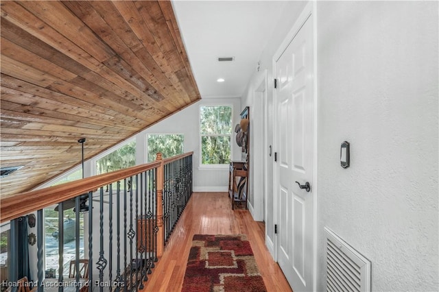 hallway with light wood-type flooring, lofted ceiling, and wood ceiling