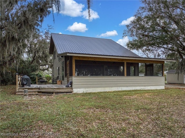 back of house with a sunroom and a yard