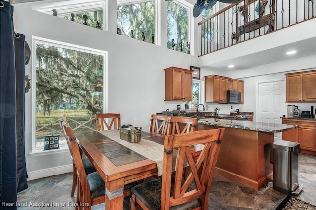 dining room featuring plenty of natural light and a towering ceiling