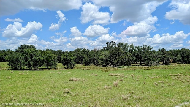 view of green lawn featuring a view of countryside