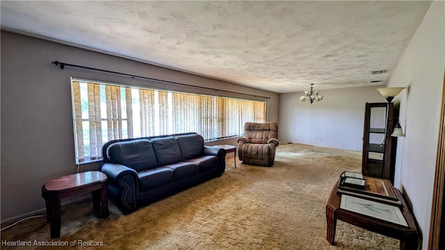 living room featuring a chandelier, carpet, and a textured ceiling