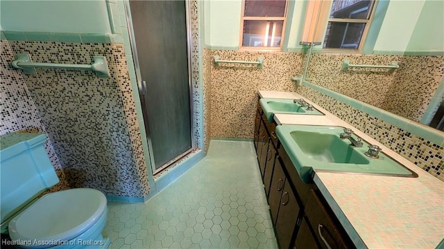 full bathroom featuring tile walls, tile patterned flooring, a shower stall, vanity, and toilet