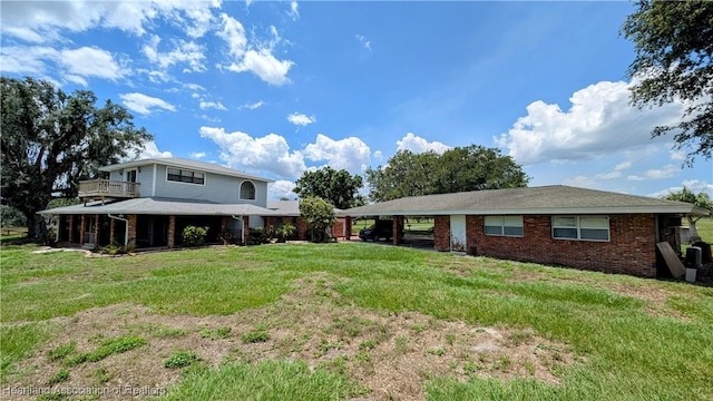 view of front facade featuring a front yard, an attached carport, and brick siding