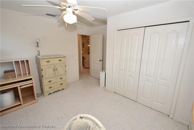 carpeted bedroom featuring a closet and ceiling fan