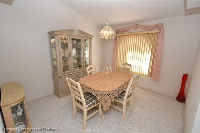 dining area featuring light carpet and a chandelier