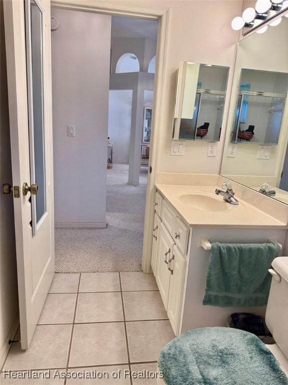 bathroom with tile patterned floors, vanity, toilet, and walk in shower