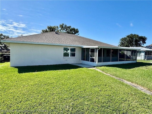 rear view of property featuring a sunroom and a yard