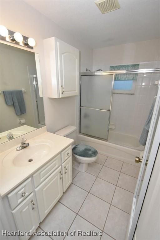 full bathroom featuring tile patterned floors, vanity, toilet, and combined bath / shower with glass door