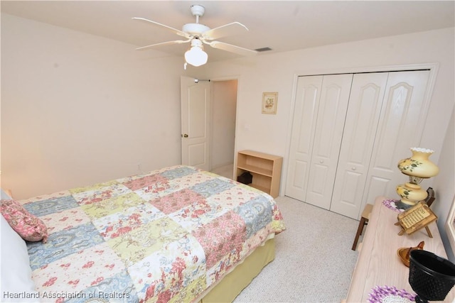 carpeted bedroom with ceiling fan and a closet