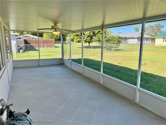 unfurnished sunroom with ceiling fan and a wealth of natural light