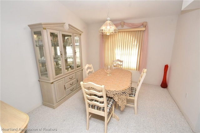 dining room featuring light carpet and an inviting chandelier