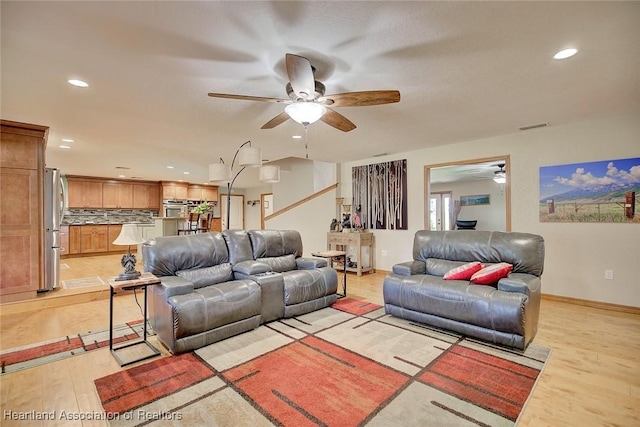 living room featuring light wood-style flooring, visible vents, a ceiling fan, and recessed lighting