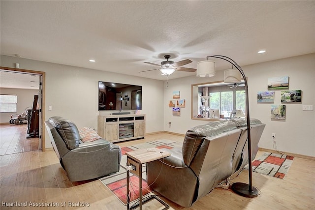 living room featuring recessed lighting, a ceiling fan, a textured ceiling, wood finished floors, and baseboards