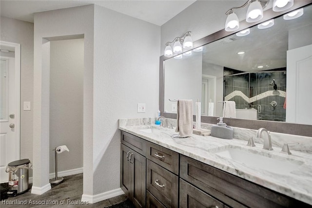 full bath with double vanity, a stall shower, visible vents, and a sink