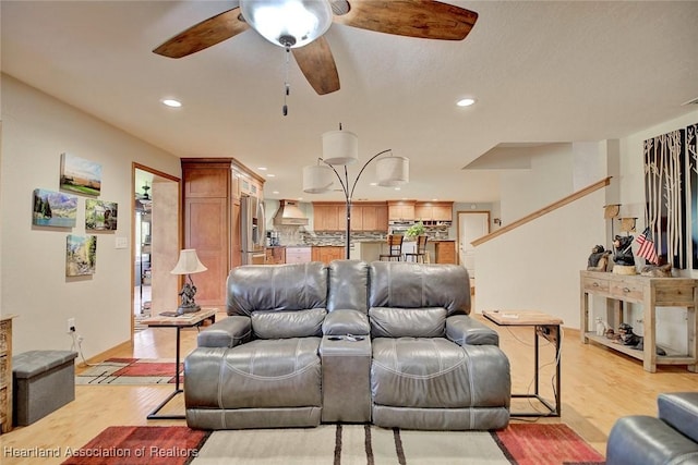 living area with ceiling fan, recessed lighting, baseboards, and light wood-style floors