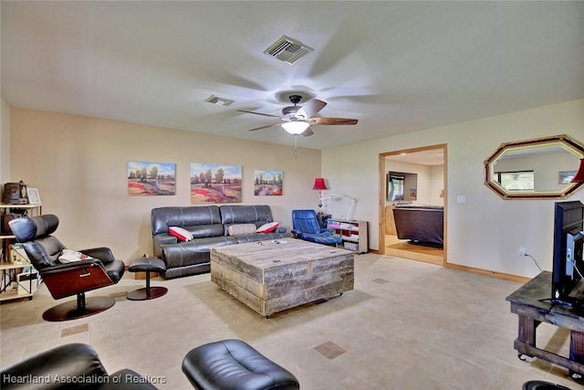 living room featuring a ceiling fan, visible vents, and baseboards