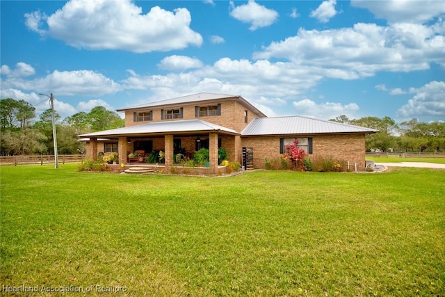 view of front of house featuring fence, a front lawn, and brick siding