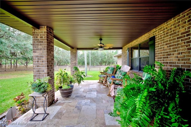 view of patio featuring ceiling fan and fence