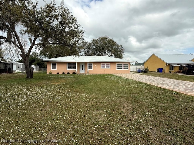 ranch-style house with a front lawn and decorative driveway