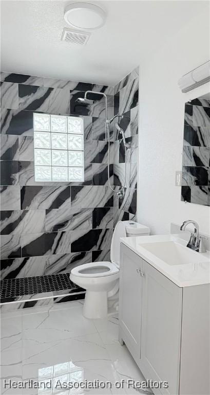 full bath featuring a stall shower, visible vents, toilet, marble finish floor, and vanity