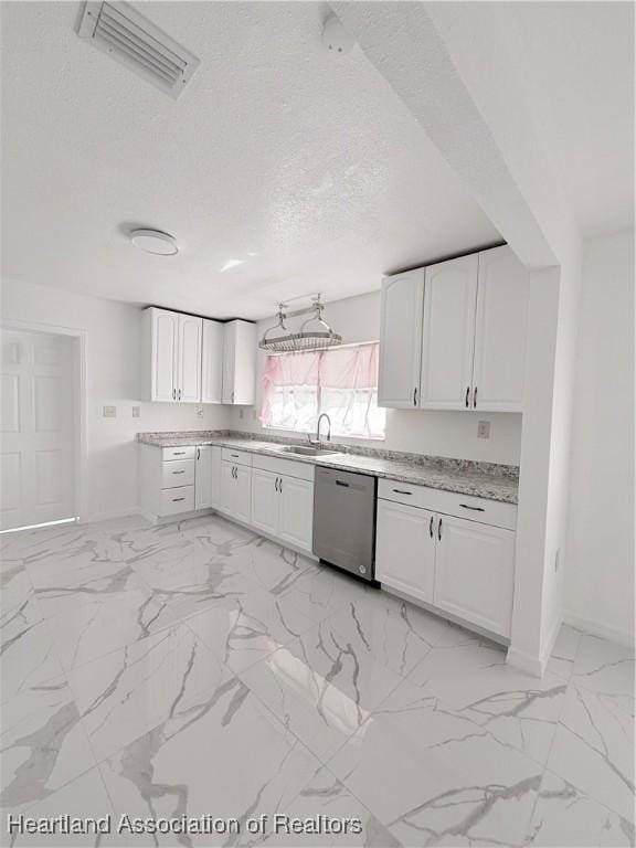 kitchen featuring visible vents, white cabinets, light countertops, stainless steel dishwasher, and a sink