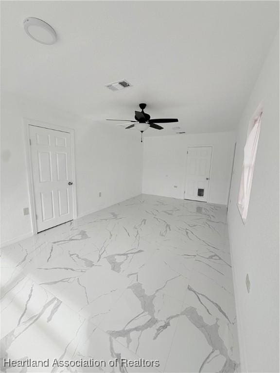 unfurnished room with marble finish floor, ceiling fan, and visible vents