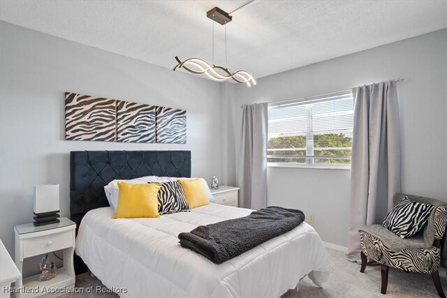 carpeted bedroom featuring baseboards and a textured ceiling