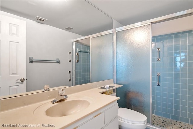 bathroom with toilet, a shower stall, visible vents, and vanity