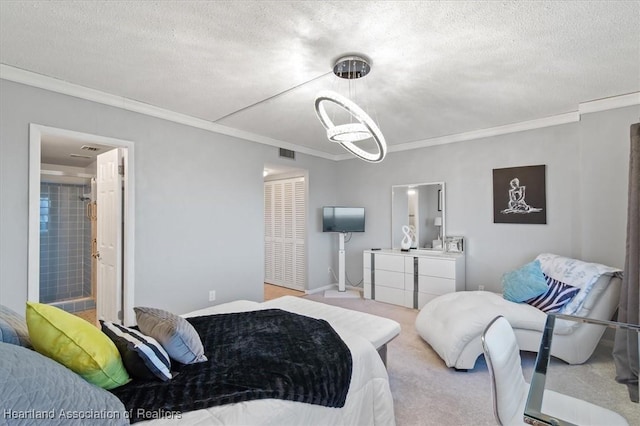 carpeted bedroom with crown molding, a textured ceiling, and ensuite bathroom