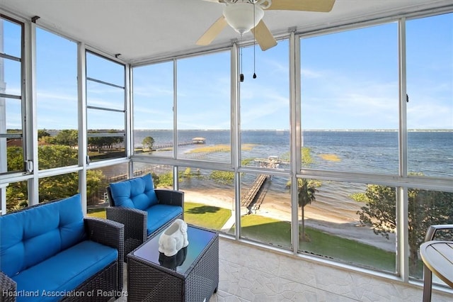 sunroom / solarium with a water view and a ceiling fan