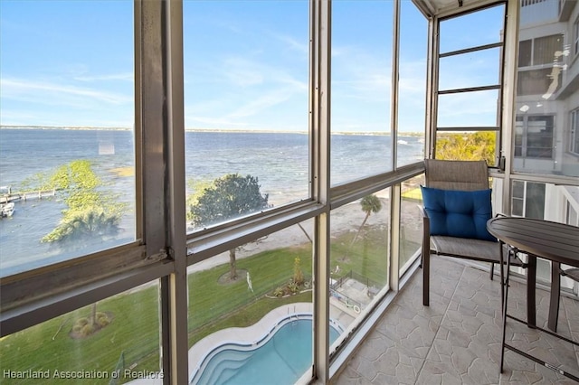 sunroom / solarium featuring a water view