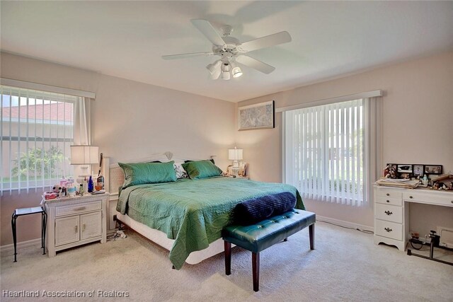 bedroom featuring light colored carpet, ceiling fan, and baseboards