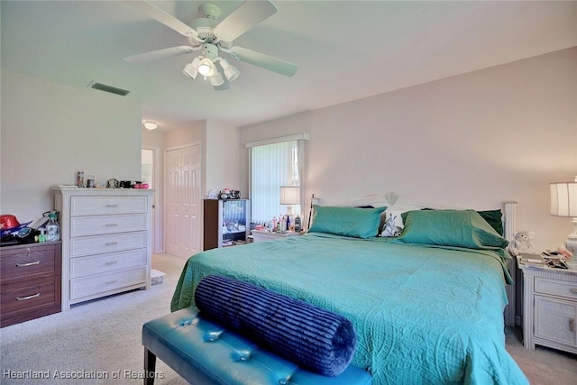 bedroom with light colored carpet, a closet, visible vents, and ceiling fan