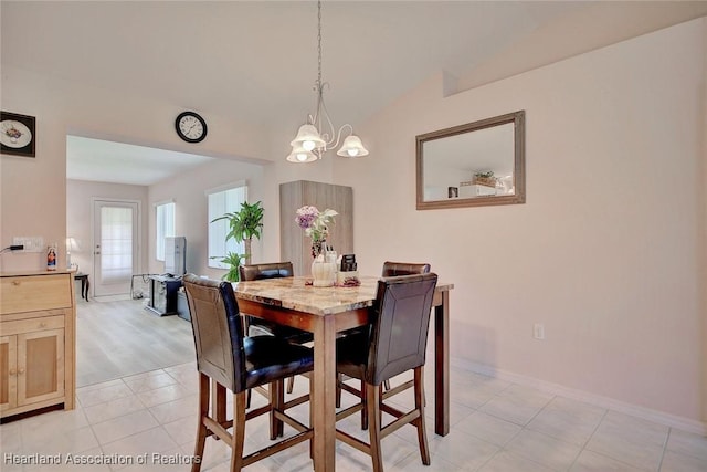 dining space featuring lofted ceiling, light tile patterned floors, baseboards, and a notable chandelier