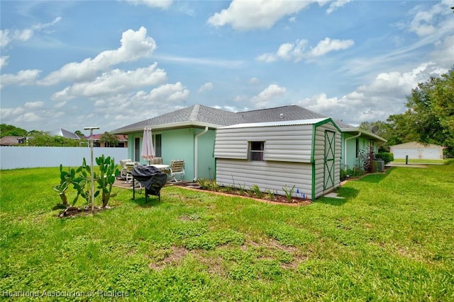 rear view of house featuring a lawn, a patio area, and fence