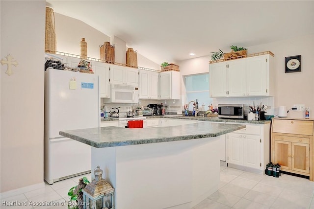 kitchen with white appliances, light tile patterned floors, and white cabinets