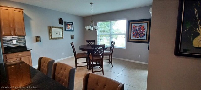 dining area with light tile patterned floors and an inviting chandelier