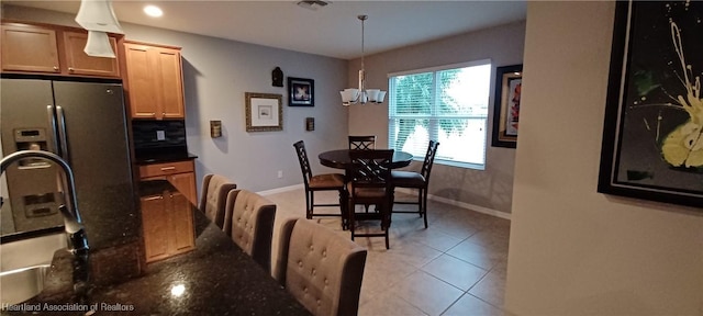 tiled dining space with a chandelier