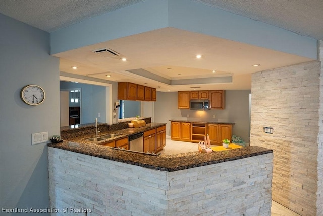 kitchen featuring sink, kitchen peninsula, a textured ceiling, a tray ceiling, and appliances with stainless steel finishes