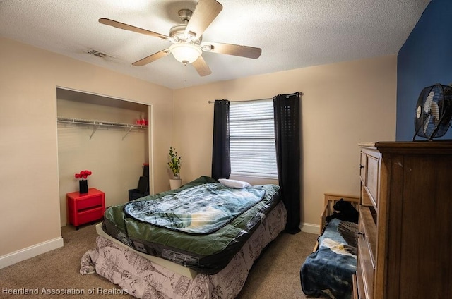 carpeted bedroom featuring a textured ceiling, a closet, and ceiling fan