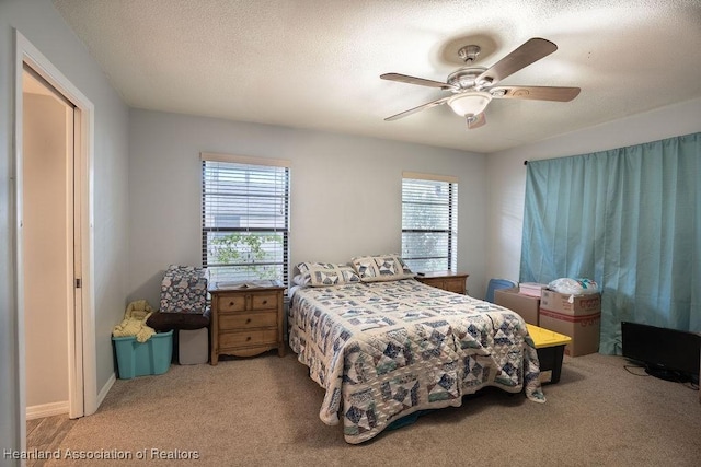 bedroom with a textured ceiling, carpet floors, and ceiling fan