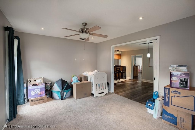 miscellaneous room with ceiling fan and dark carpet