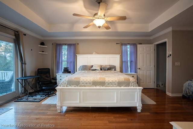 bedroom featuring ceiling fan, wood-type flooring, access to outside, and a tray ceiling