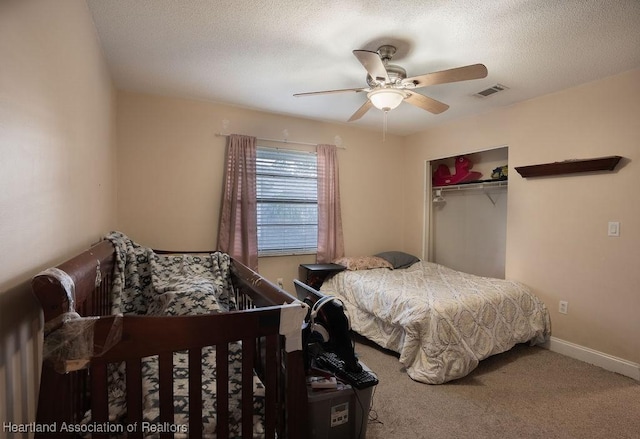 bedroom with ceiling fan, carpet floors, a textured ceiling, and a closet