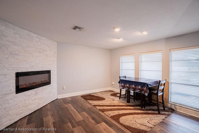 dining space with dark hardwood / wood-style flooring and a textured ceiling