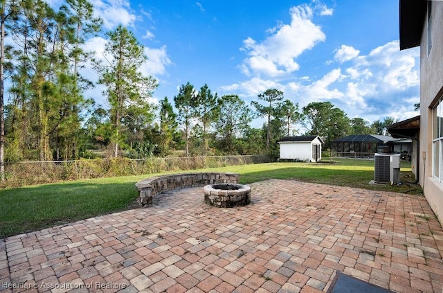 view of patio featuring a shed, a fire pit, and cooling unit